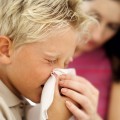 Flu Boy Blowing His Nose into a Handkerchief and Sneezing
