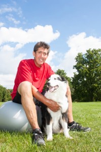 Man outside playing with dog