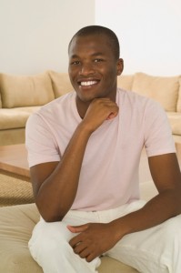 Man sitting on sofa, smiling