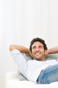Smiling man, reclining on couch