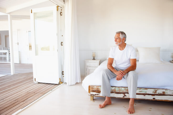 Man sitting on edge of bed
