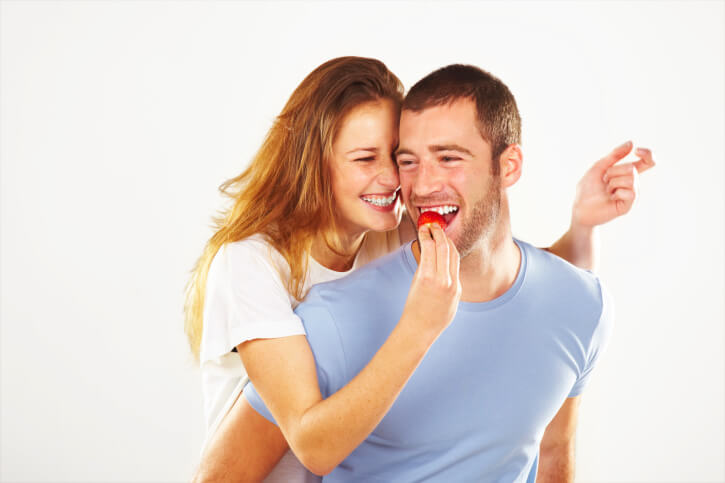 woman feeding man a strawberry