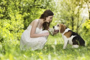 young woman outdoors petting a beagle