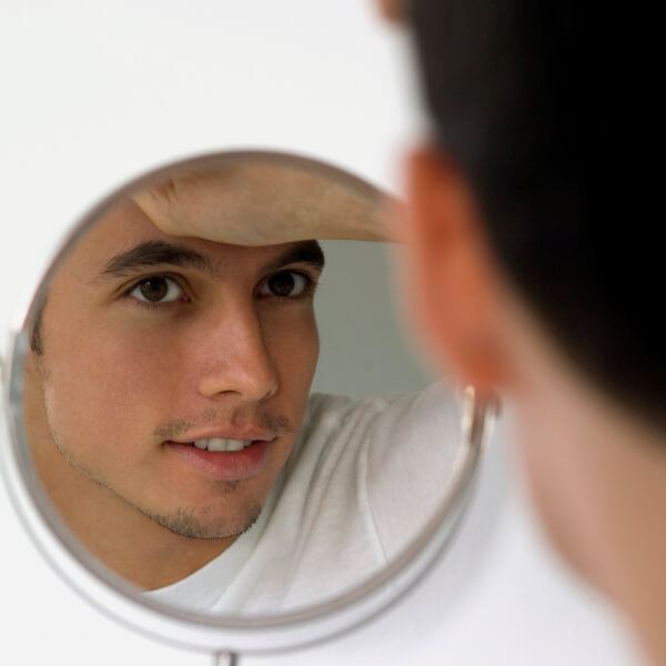 young man looking in mirror