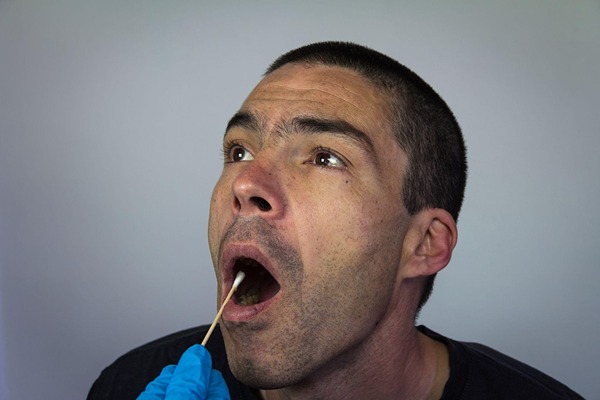 Man doing a saliva test Man doing a saliva test