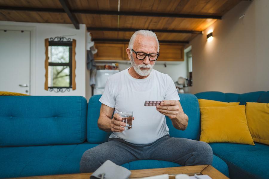 elderly man taking pills