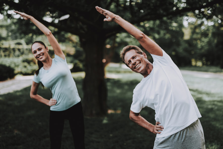 Man and woman stretching in a park.