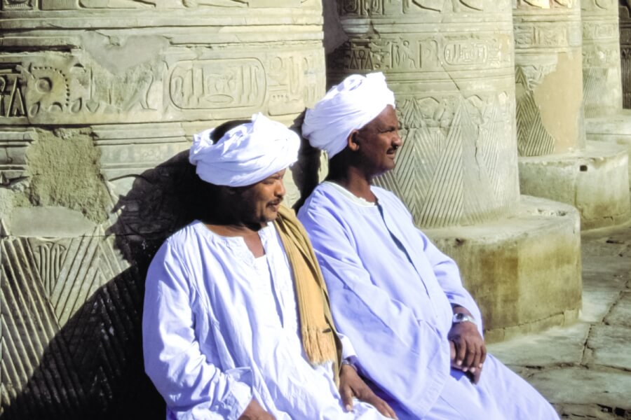Two men sitting next to large columns.