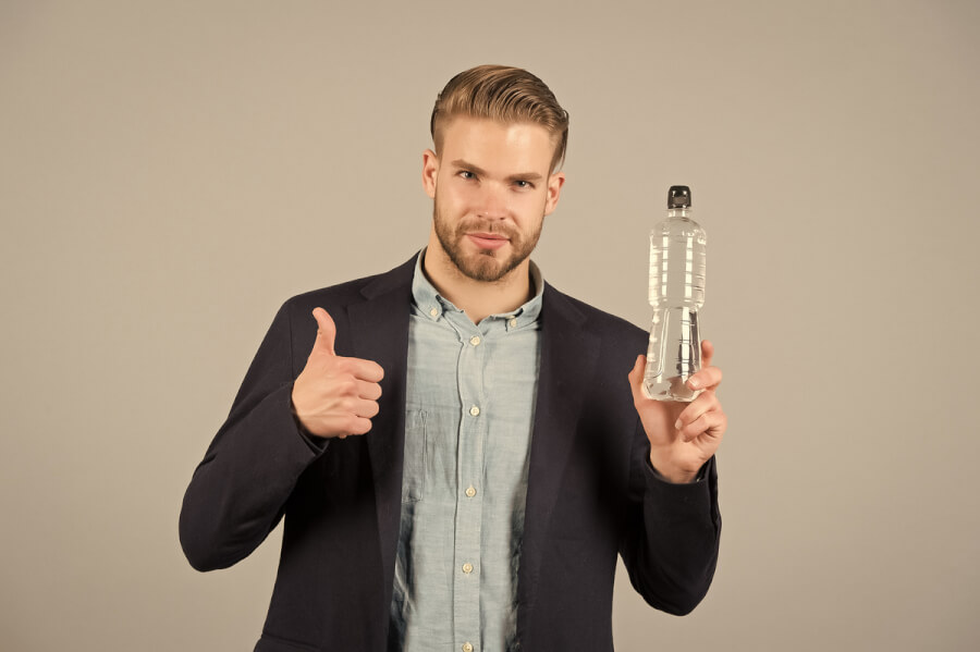 Man holding a water bottle and giving thumbs up.