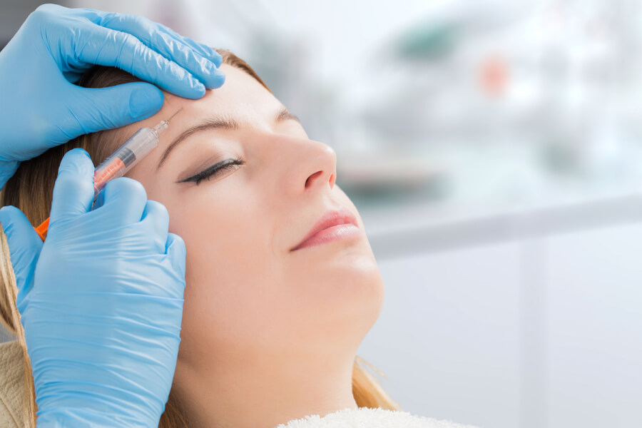 Woman getting botox injections above her brow.