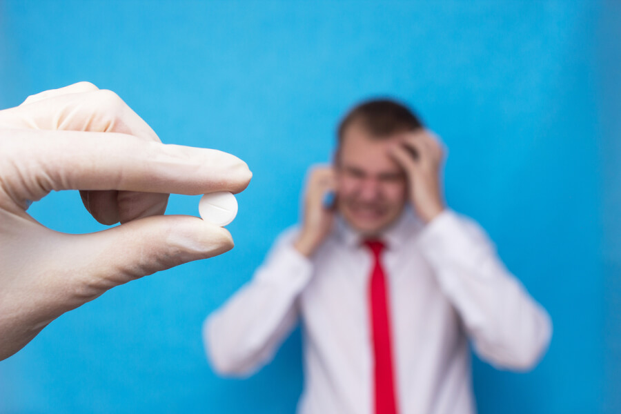 Man talking on the phone appearing in pain.