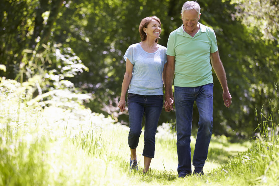 Older couple walking outside.