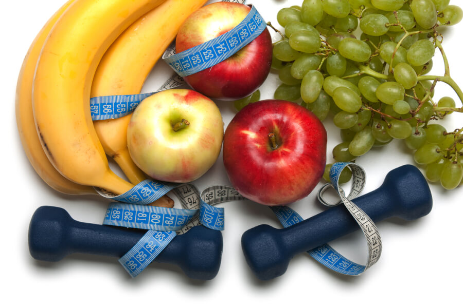 Tabletop with bananas, apples and grapes.