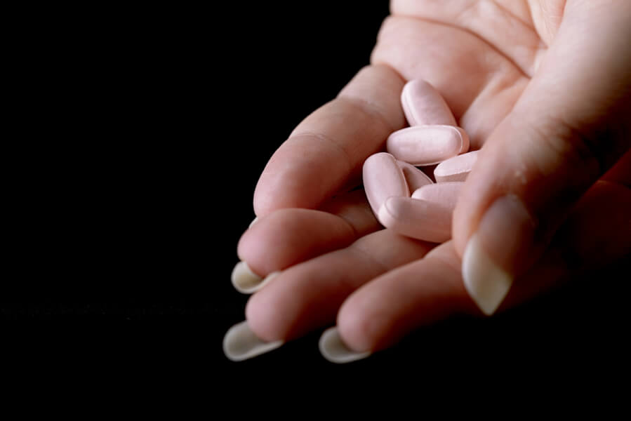 Hand holding a bunch of pills.