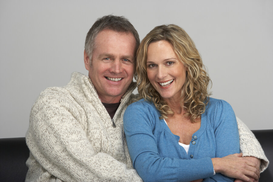 Happy couple hugging on a couch.
