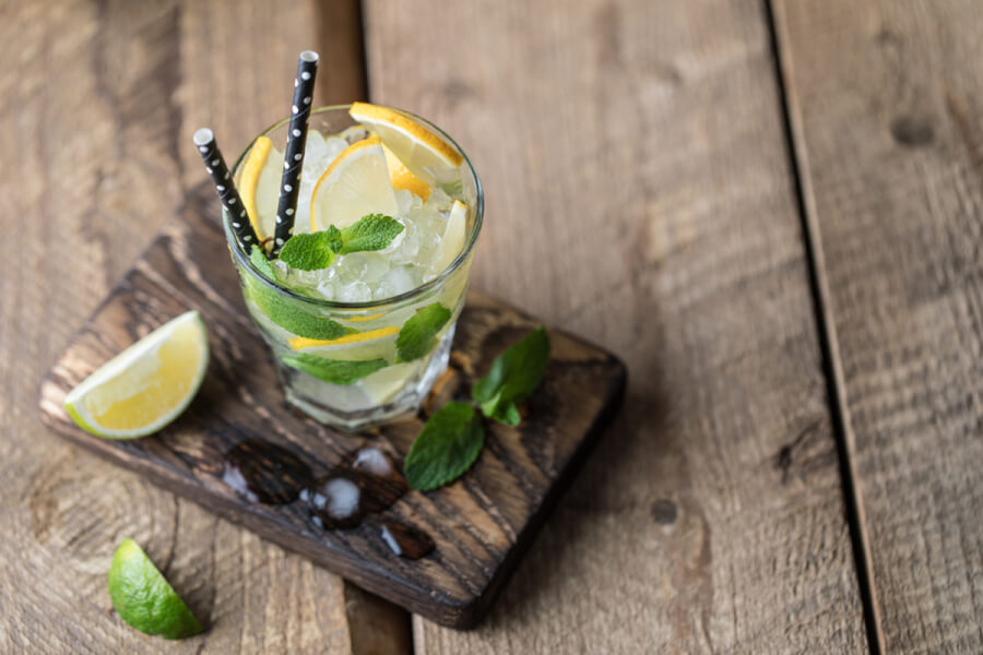 Alcoholic beverage in a glass with lemon and lime.