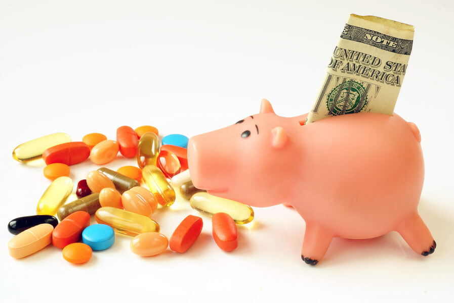 Pink plastic piggy bank with paper money and pills.