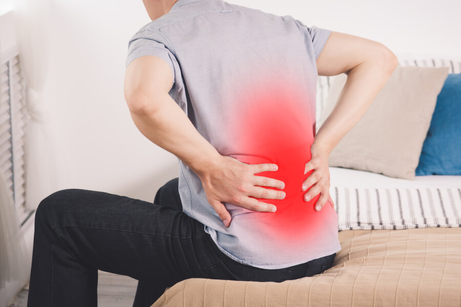 Person holding their back appearing in pain.