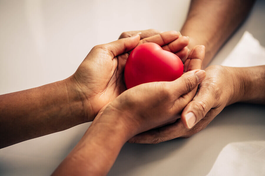 Person holding a heart shaped rock.