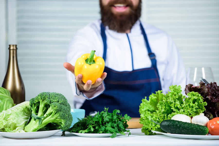 Holding a yellow pepper.