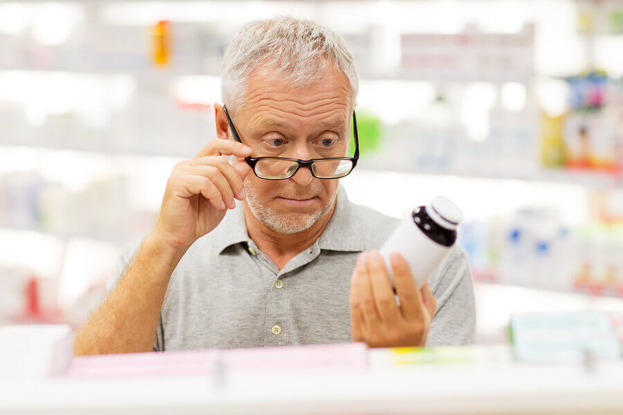 Man looking at a label on a pill bottle