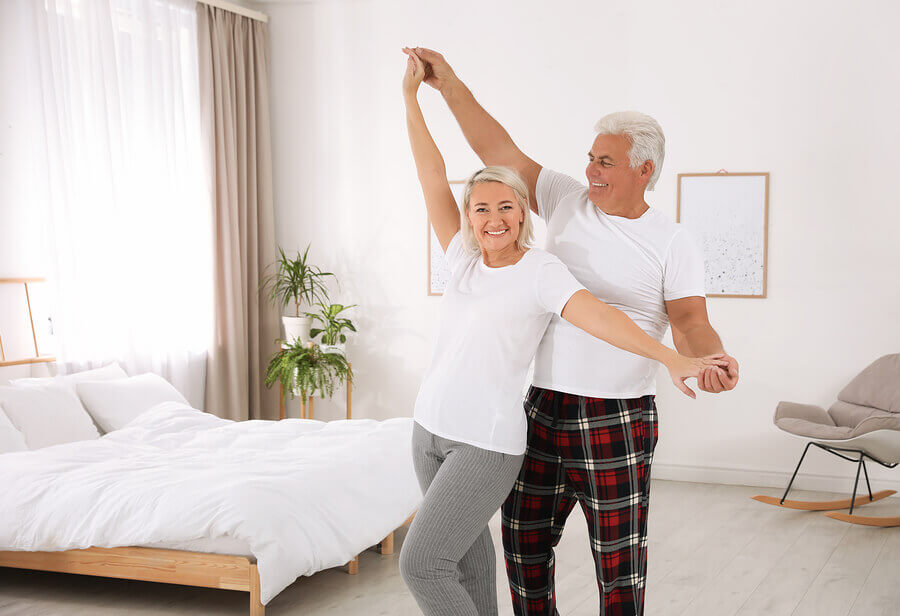 Happy older couple dancing in their bedroom
