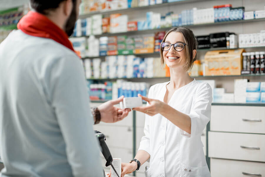 Pharmacist handing medication to a customer.