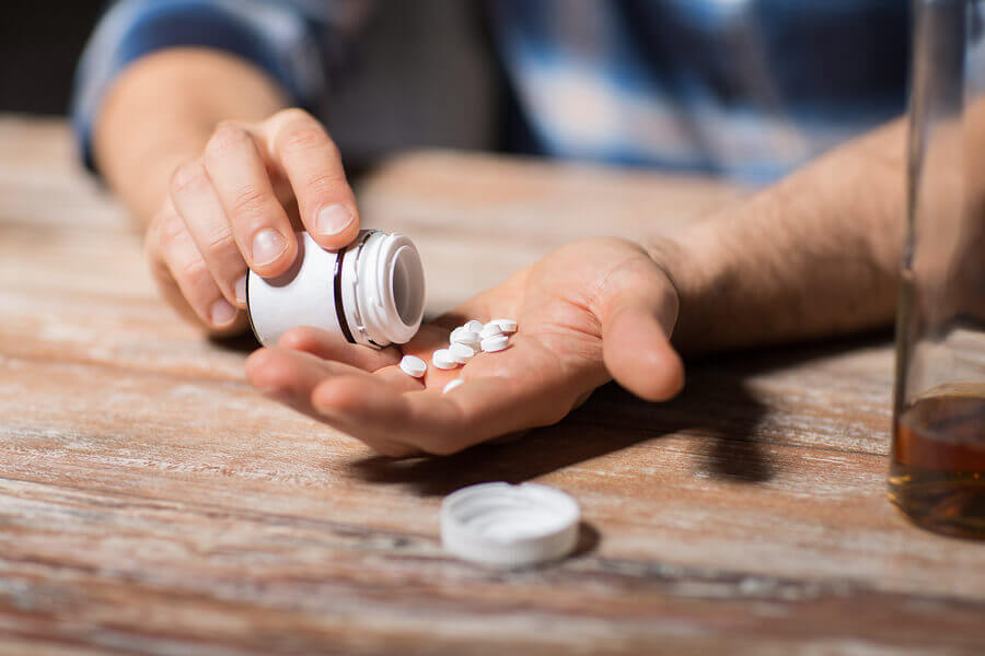 Pouring pills from a container into a hand.