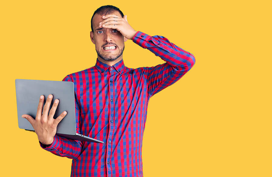 Man holding his hand to his forehead appearing distraught.