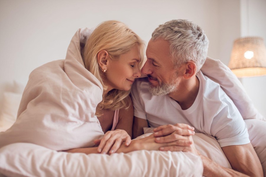 middle-aged couple snuggling in bed
