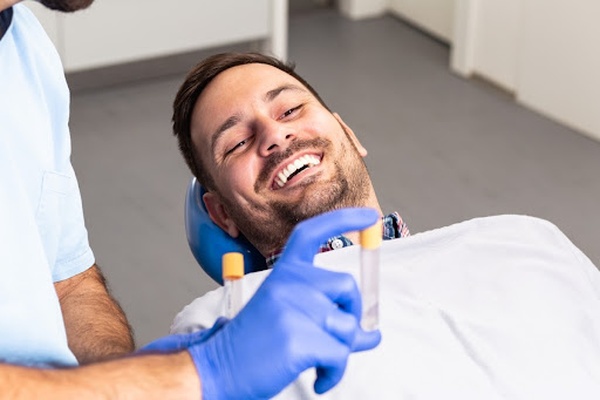 Happy man looking at a test tube Happy man looking at a test tube