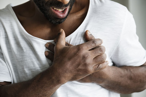 man holding his hands over his heart man holding his hands over his heart