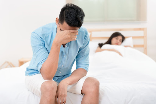 man sitting at the edge of bed man sitting at the edge of bed