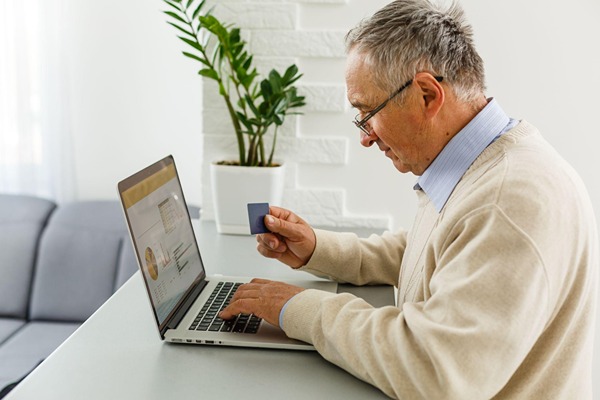 An older man typing on his laptop An older man typing on his laptop