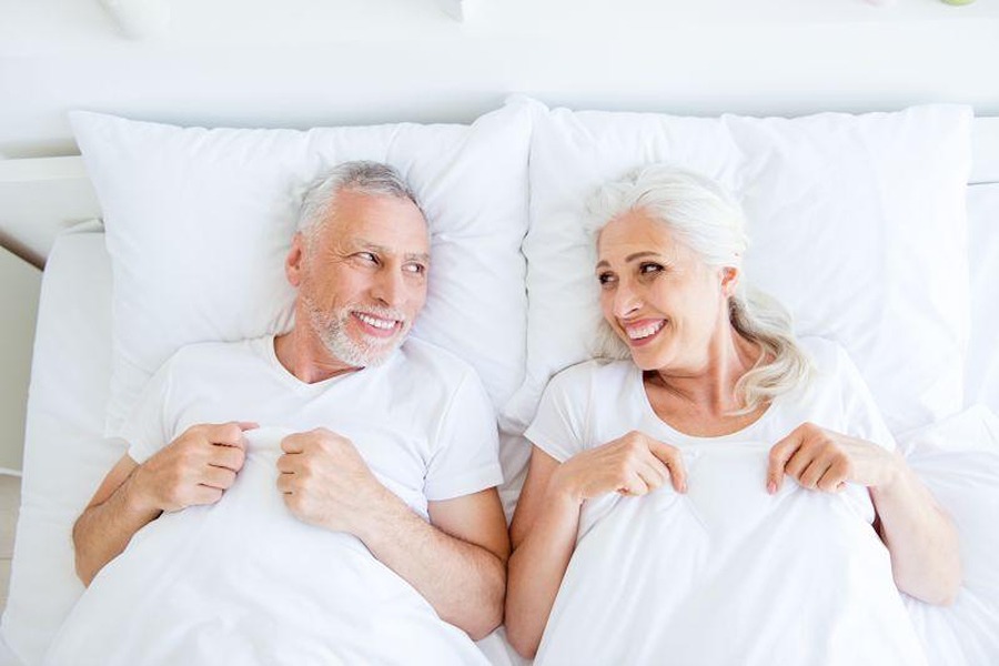 Senior couple smiling in bed