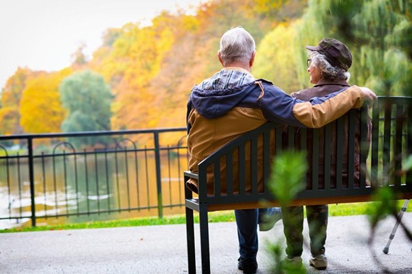 Older couple hugging on a bench Older couple hugging on a bench
