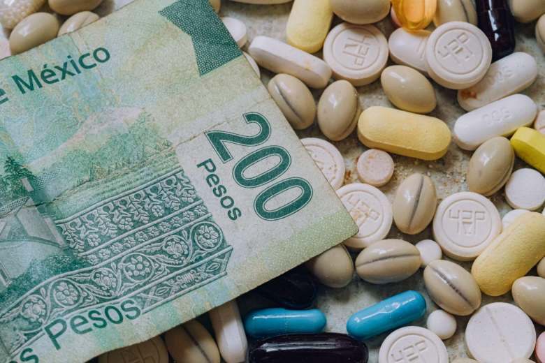 mix of pills with a Mexican bill of two hundred pesos on top