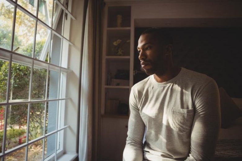 man daydreaming at window
