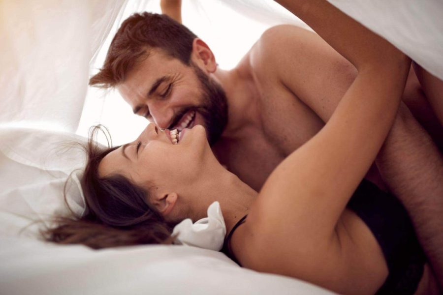 happy young couple under the sheets