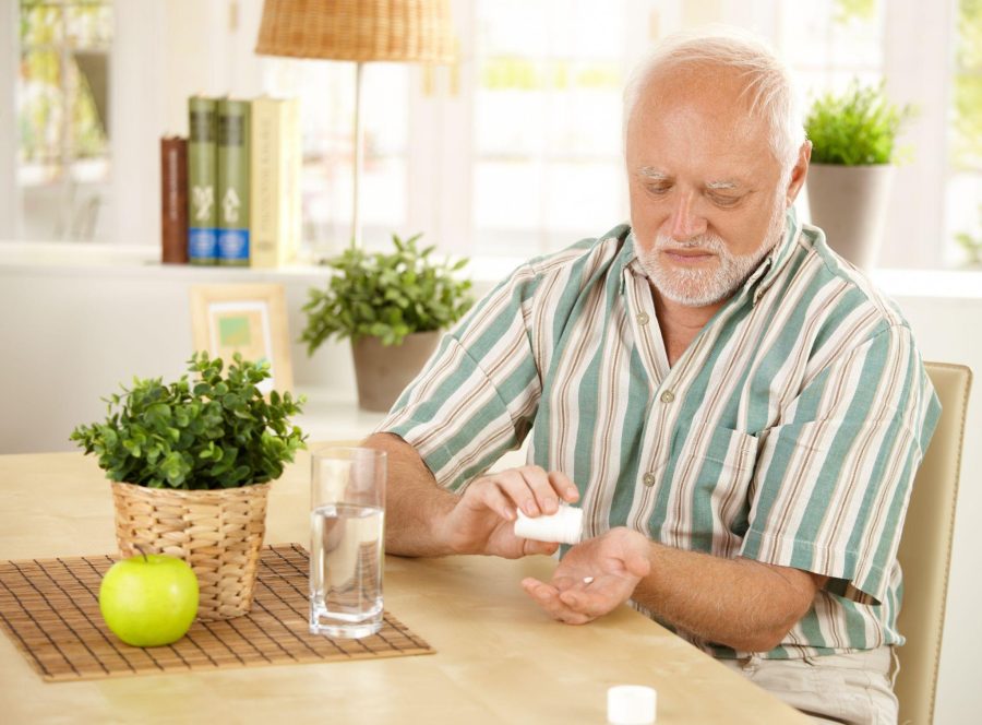 elderly man taking a tablet