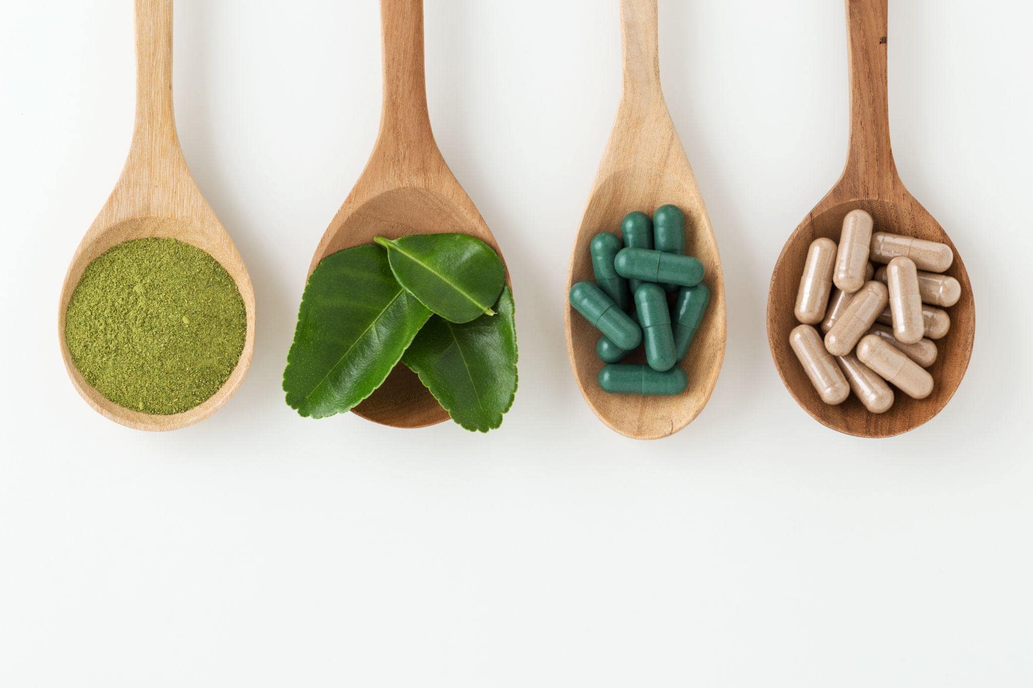 leaves and pills in spoons