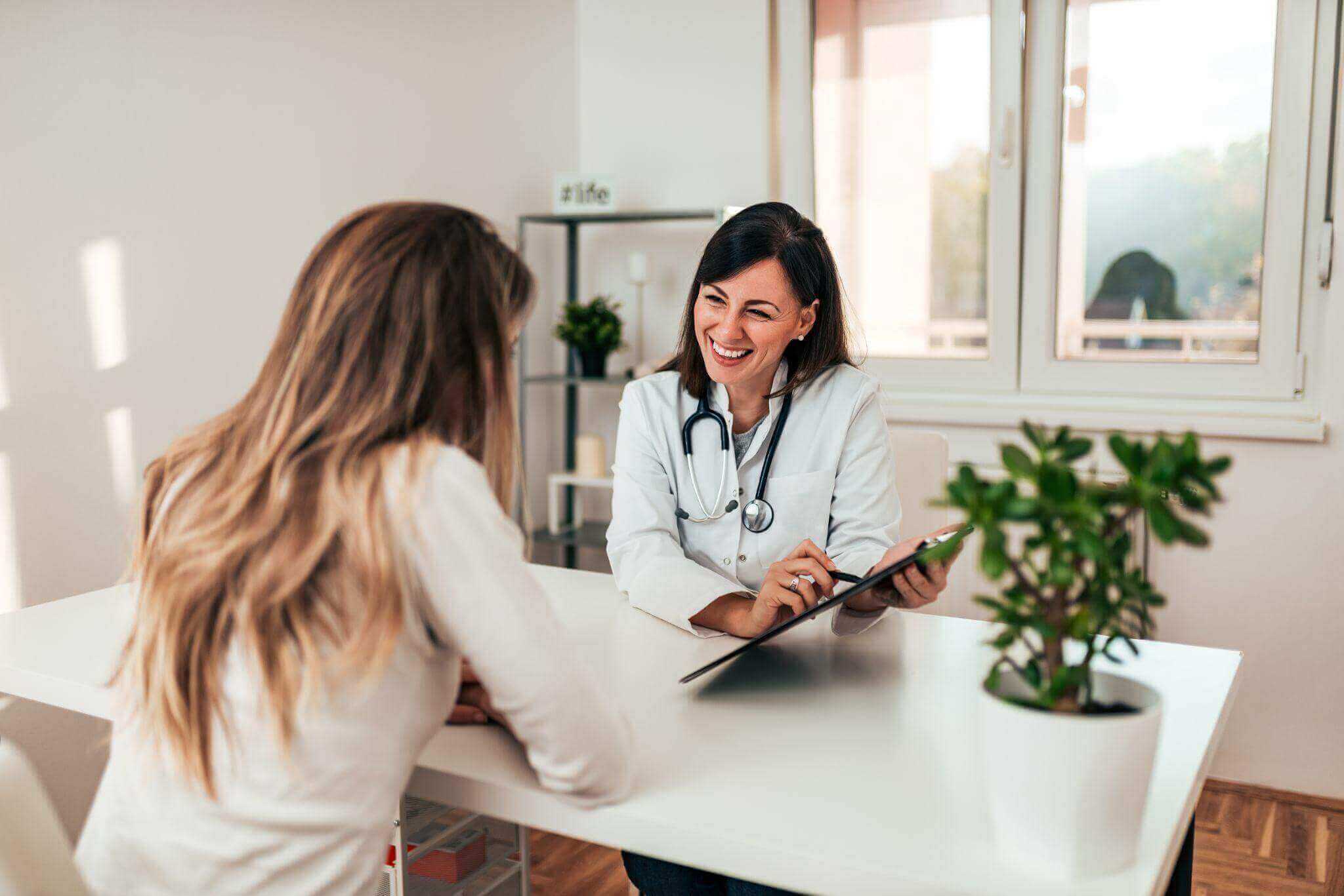 a smiling female doctor and a female patient