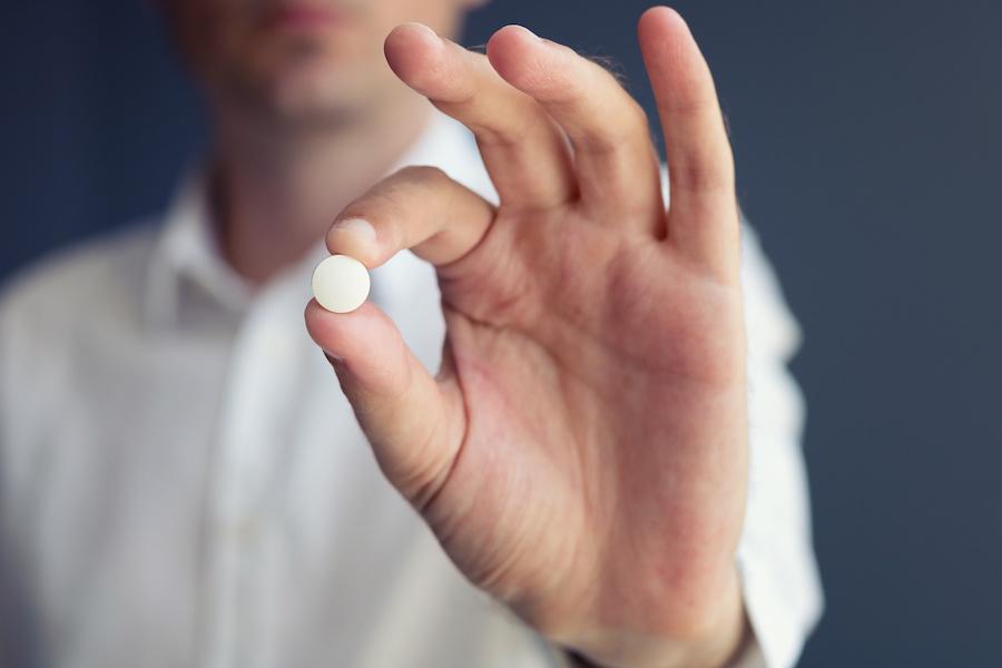 person holding an aspirin