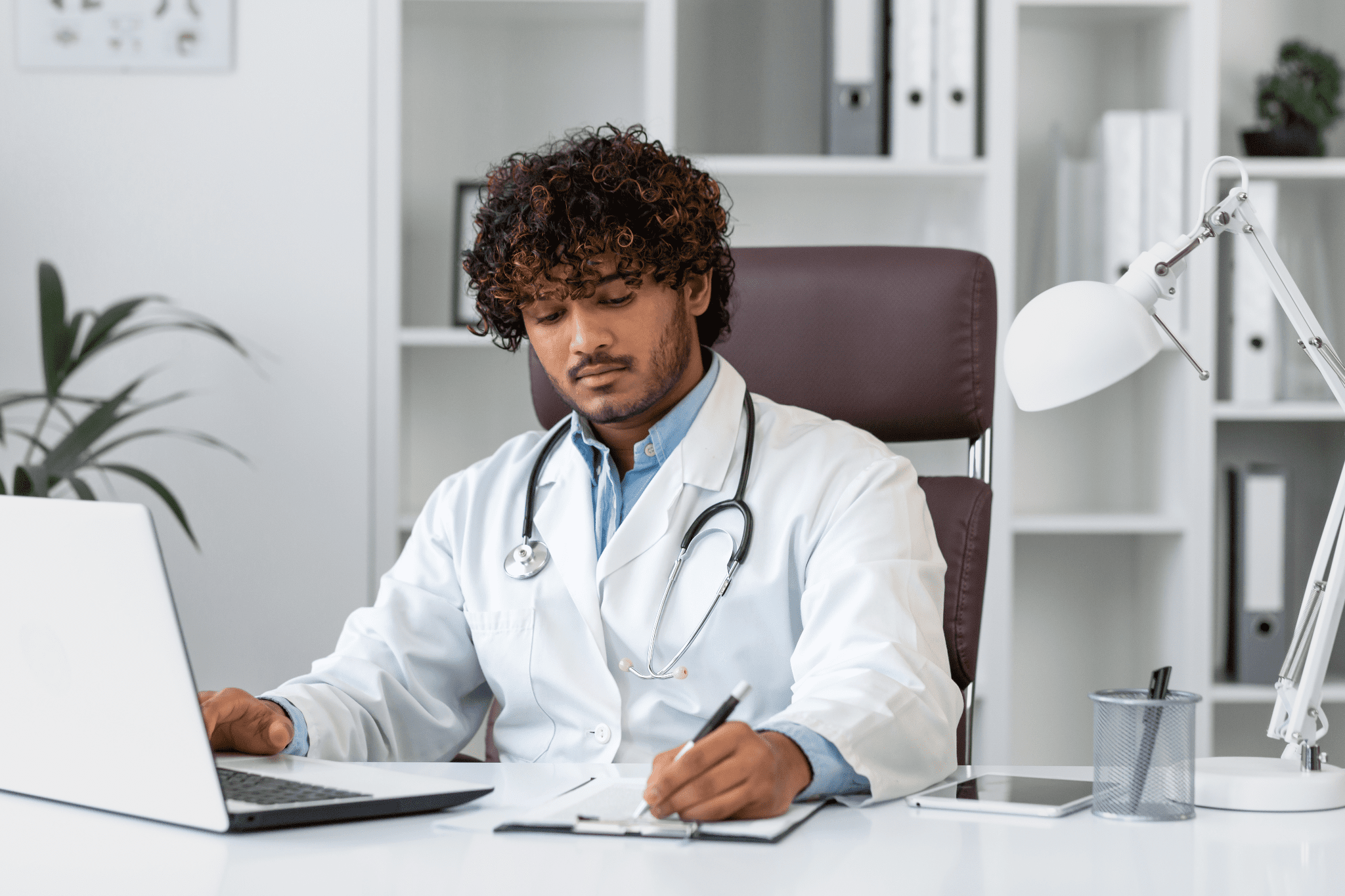 young doctor sitting at his desk on an online call