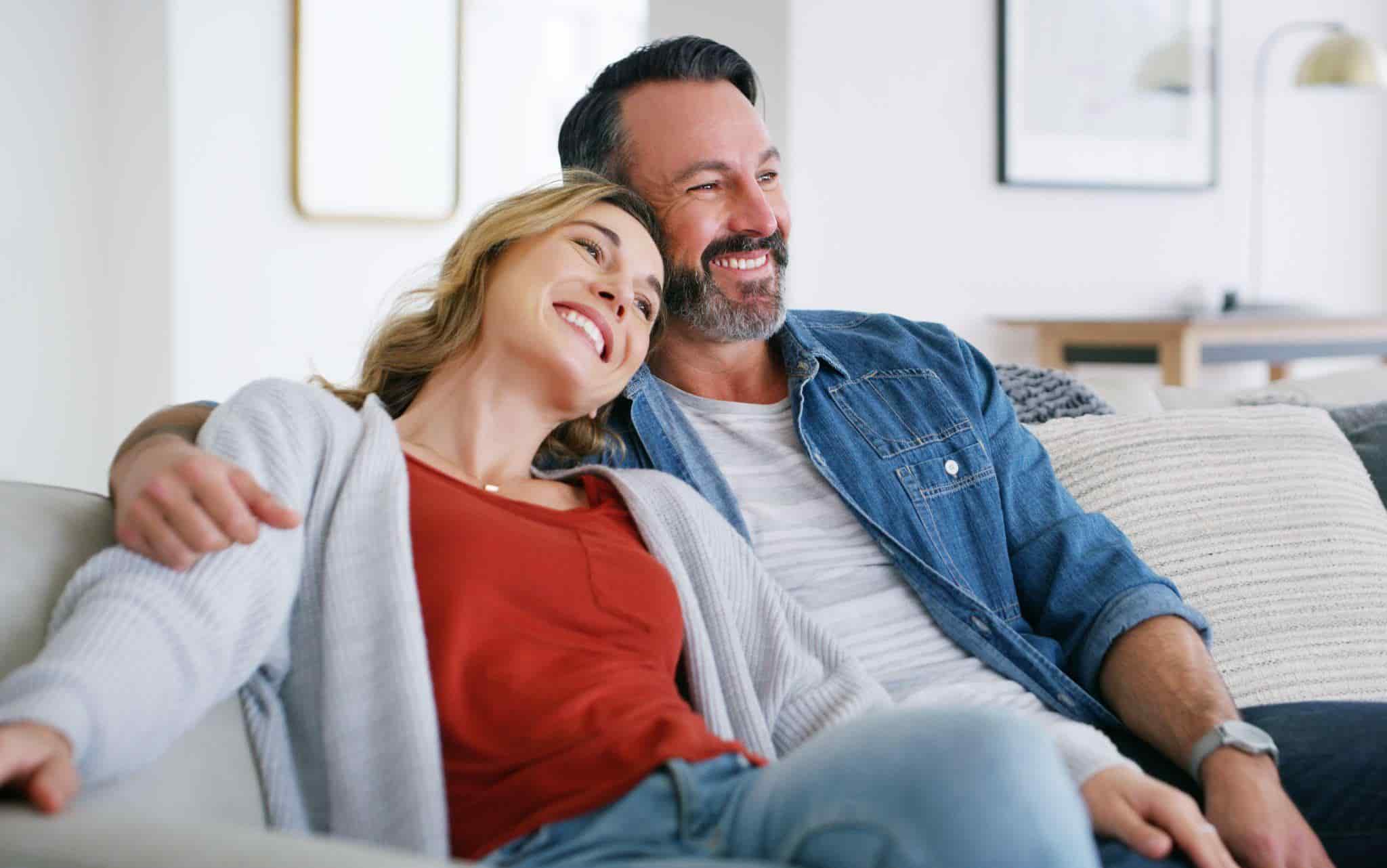 smiling couple sitting on a couch