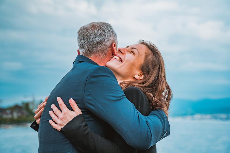 older couple hugging each other at the beach