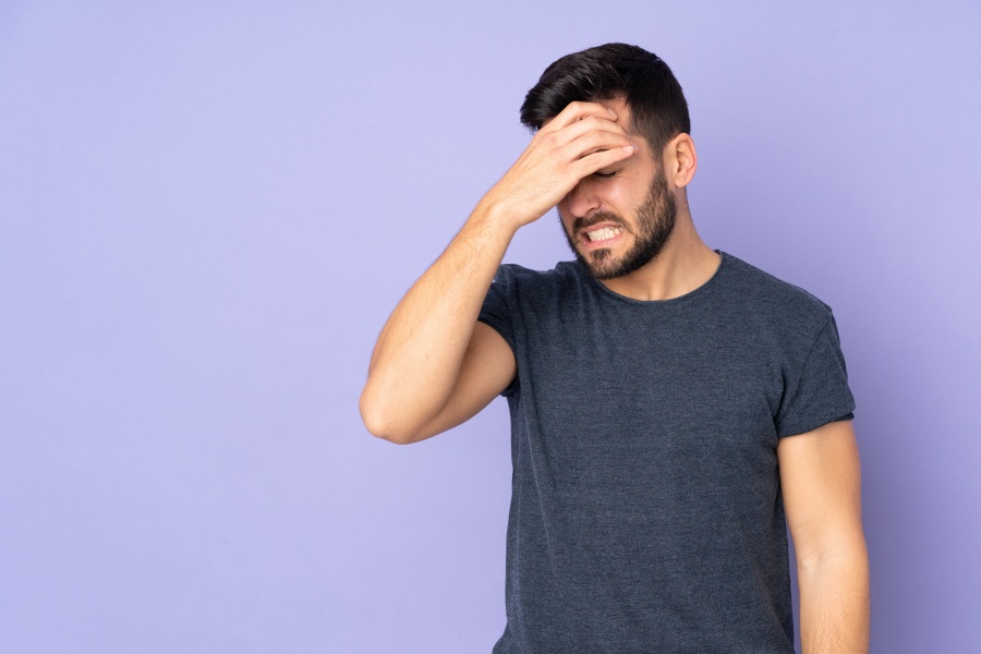 man holding his head in pain