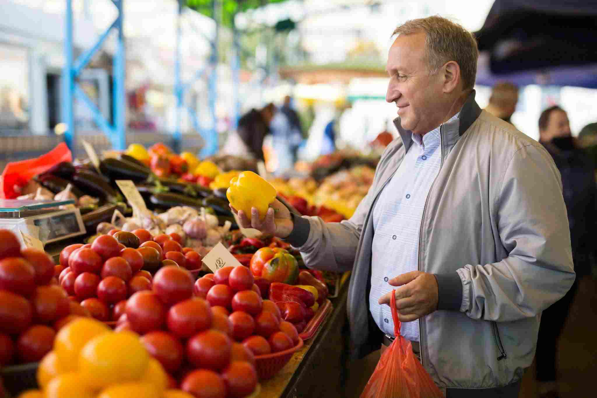 man picking vegretables at a market