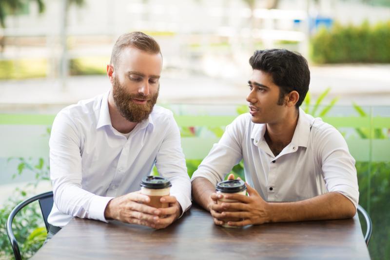 gay couple having a serious talk at a cafe
