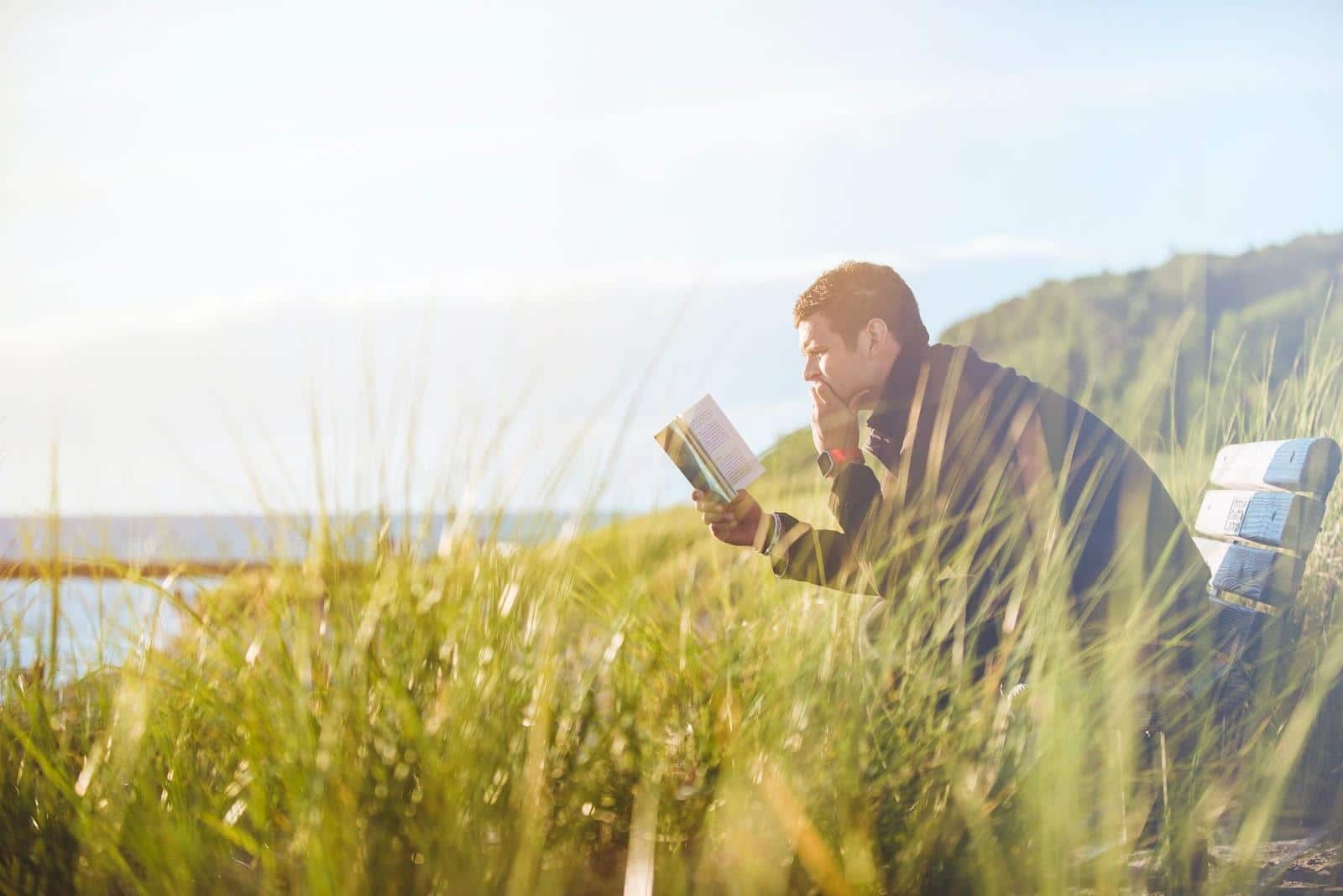 man reading a book outdoors